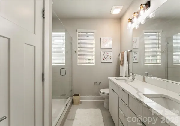 a bathroom with double vanity sink a mirror and a bathtub