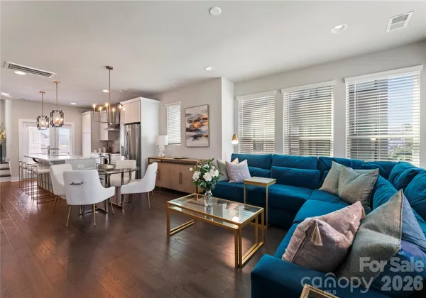 a living room with furniture wooden floor and a large window