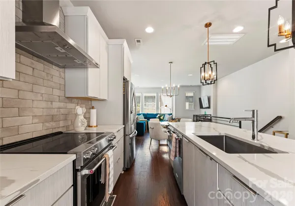 a kitchen with stainless steel appliances a sink a stove and a wooden floors