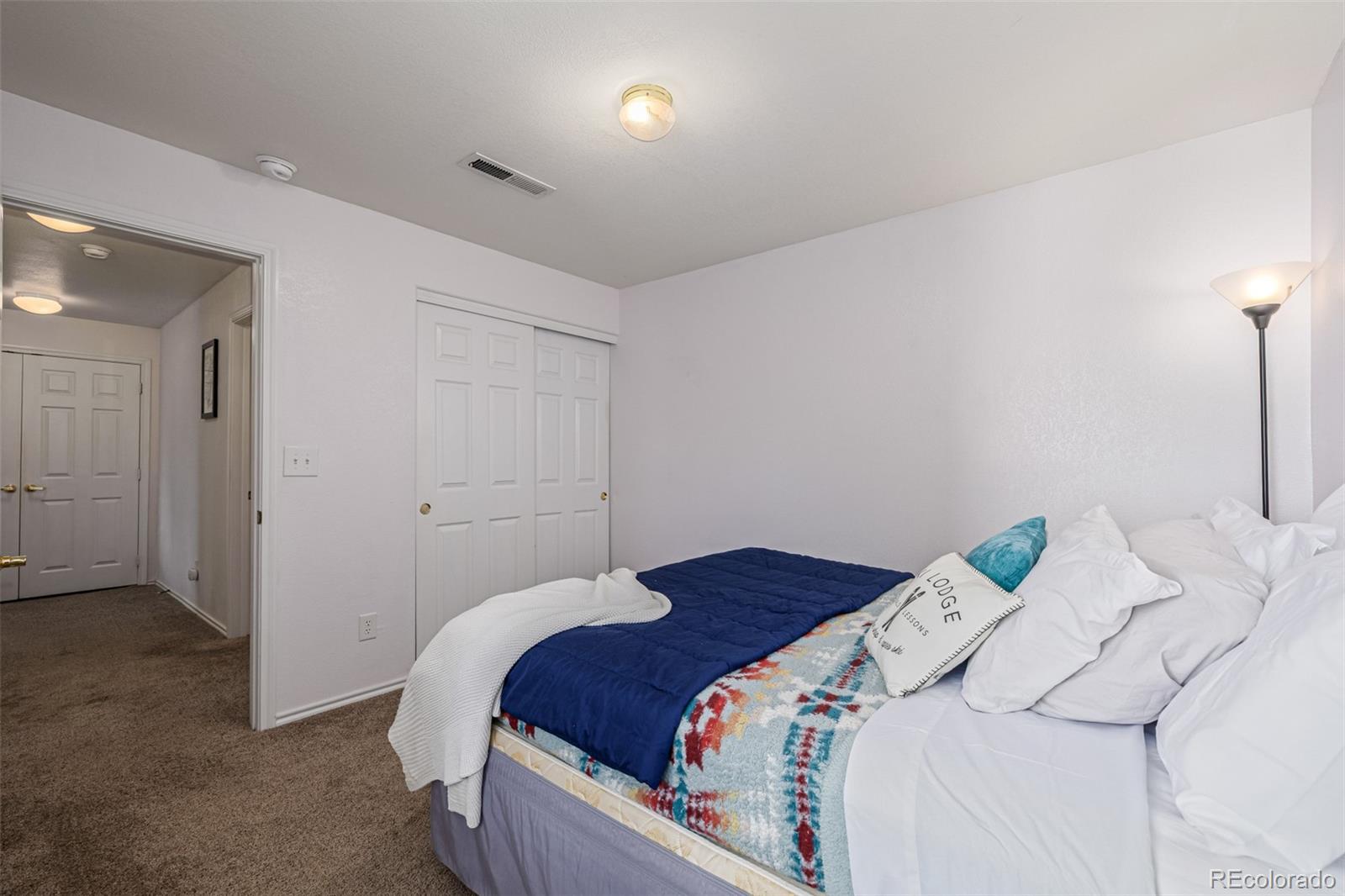 3976 Riviera Grove, Unit 203 Colorado Springs, CO 80922 - Photo 12 of 22 a bedroom with a bed and a lamp