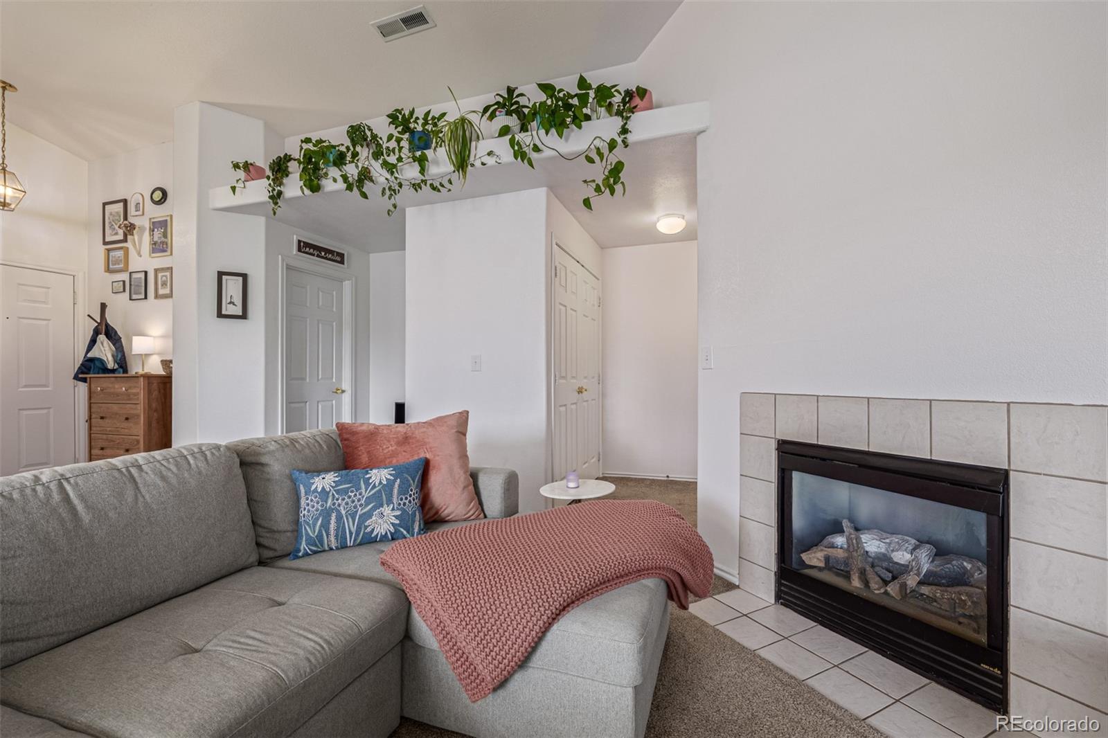 3976 Riviera Grove, Unit 203 Colorado Springs, CO 80922 - Photo 6 of 22 a living room with furniture a fireplace and a fireplace