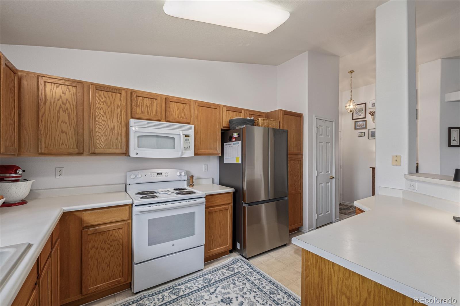 3976 Riviera Grove, Unit 203 Colorado Springs, CO 80922 - Photo 9 of 22 a kitchen with a refrigerator sink stove and cabinets
