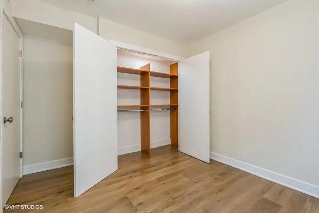 a view of empty room with wooden floor and entryway