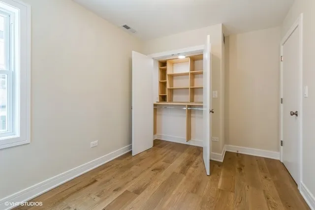 a view of empty room with wooden floor and window