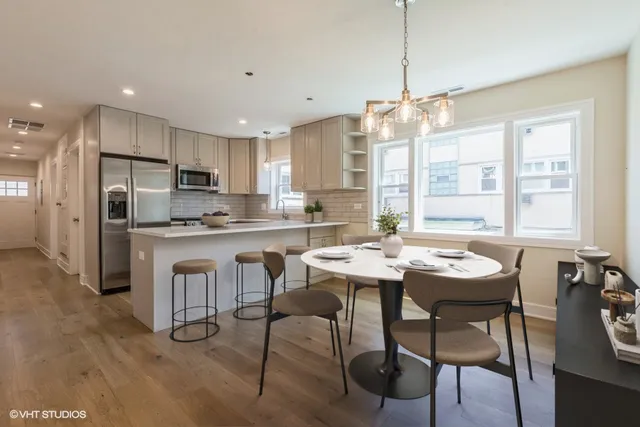 a kitchen with refrigerator a sink and chairs