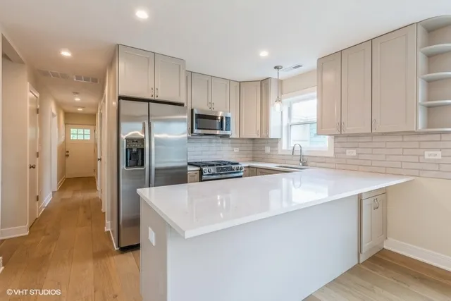 a kitchen with stainless steel appliances granite countertop a sink a refrigerator and a stove