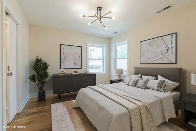 a bedroom with a large bed and a chandelier