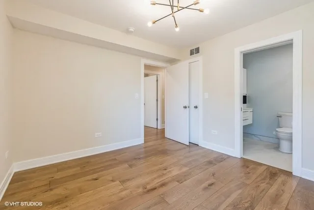 wooden floor in an empty room with a bathroom