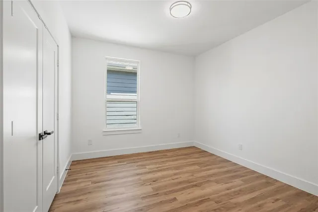 an empty room with wooden floor and a window