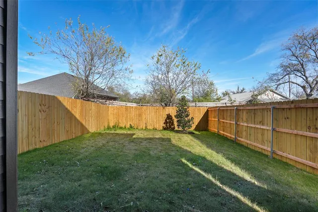a view of a backyard with wooden fence