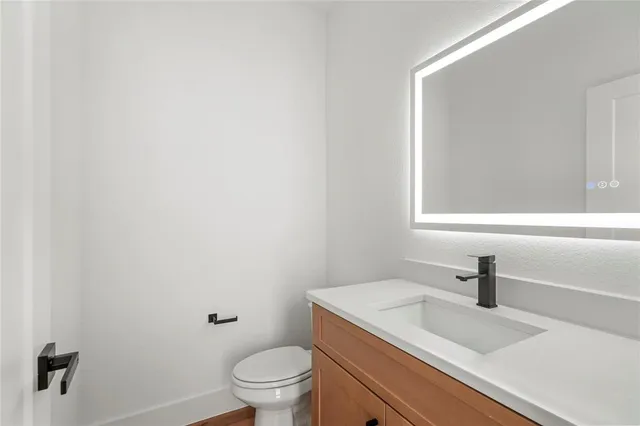 a bathroom with a sink a toilet and a mirror