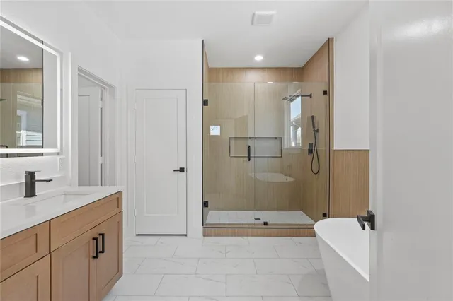 a bathroom with a granite countertop sink a toilet and shower