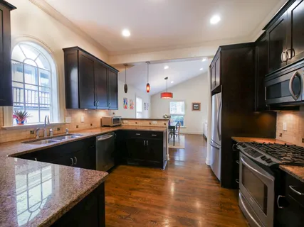 a kitchen with stainless steel appliances kitchen island granite countertop a stove a sink and a refrigerator