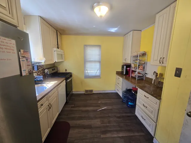 a kitchen with stainless steel appliances granite countertop a stove a sink and a refrigerator