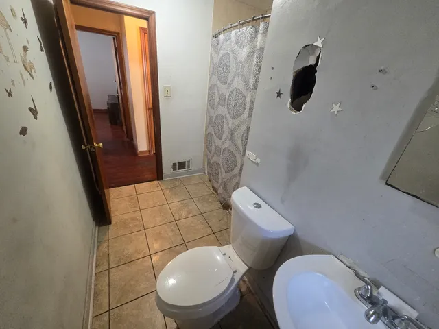 a white toilet sitting next to a bathroom sink and a shower