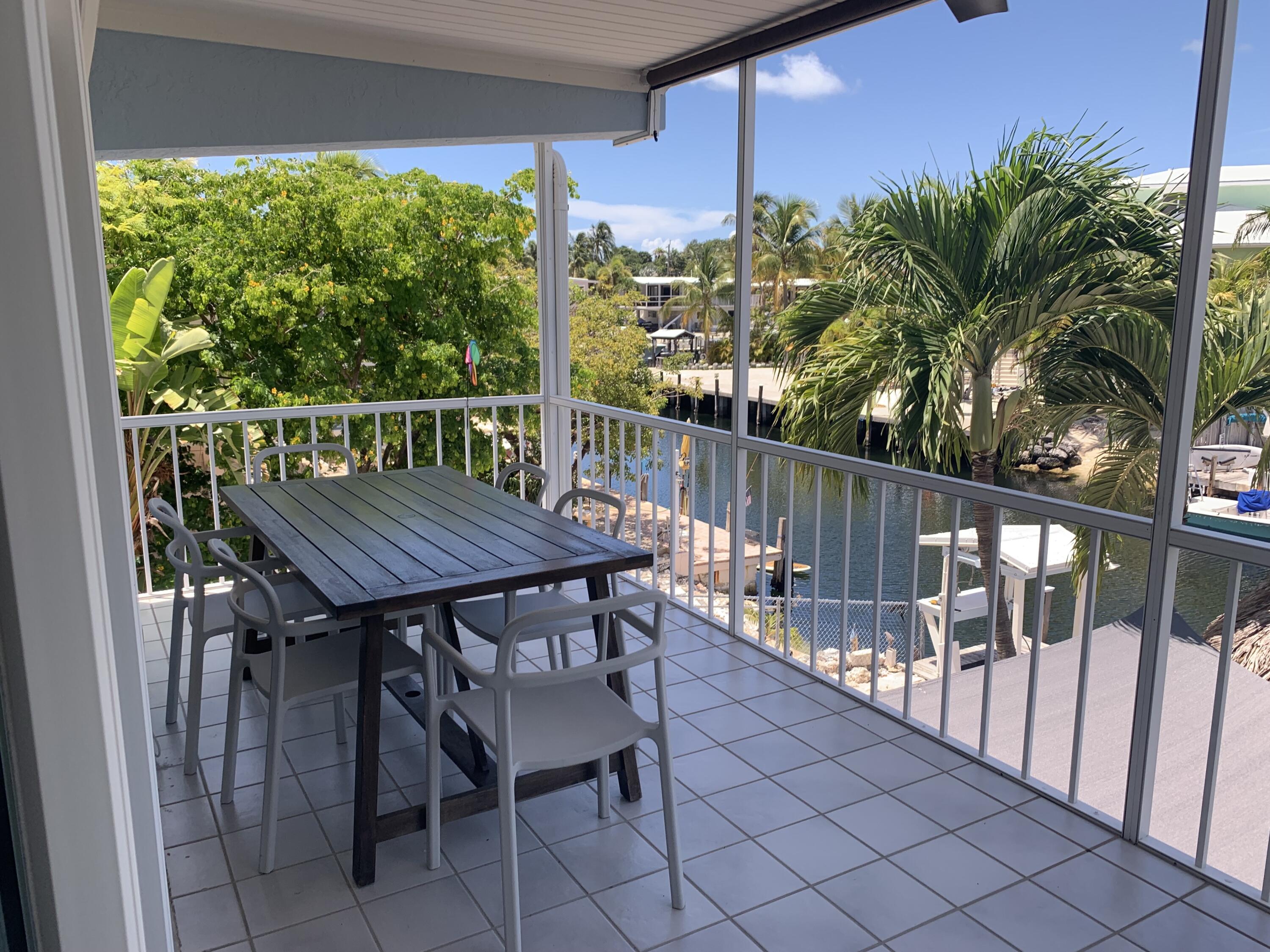 112 Captains Court Tavernier, FL 33070 - Photo 15 of 41 a view of a wooden table and chairs on the roof deck