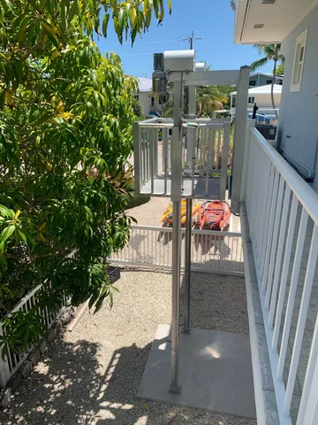 a view of pool with lawn chairs under an umbrella