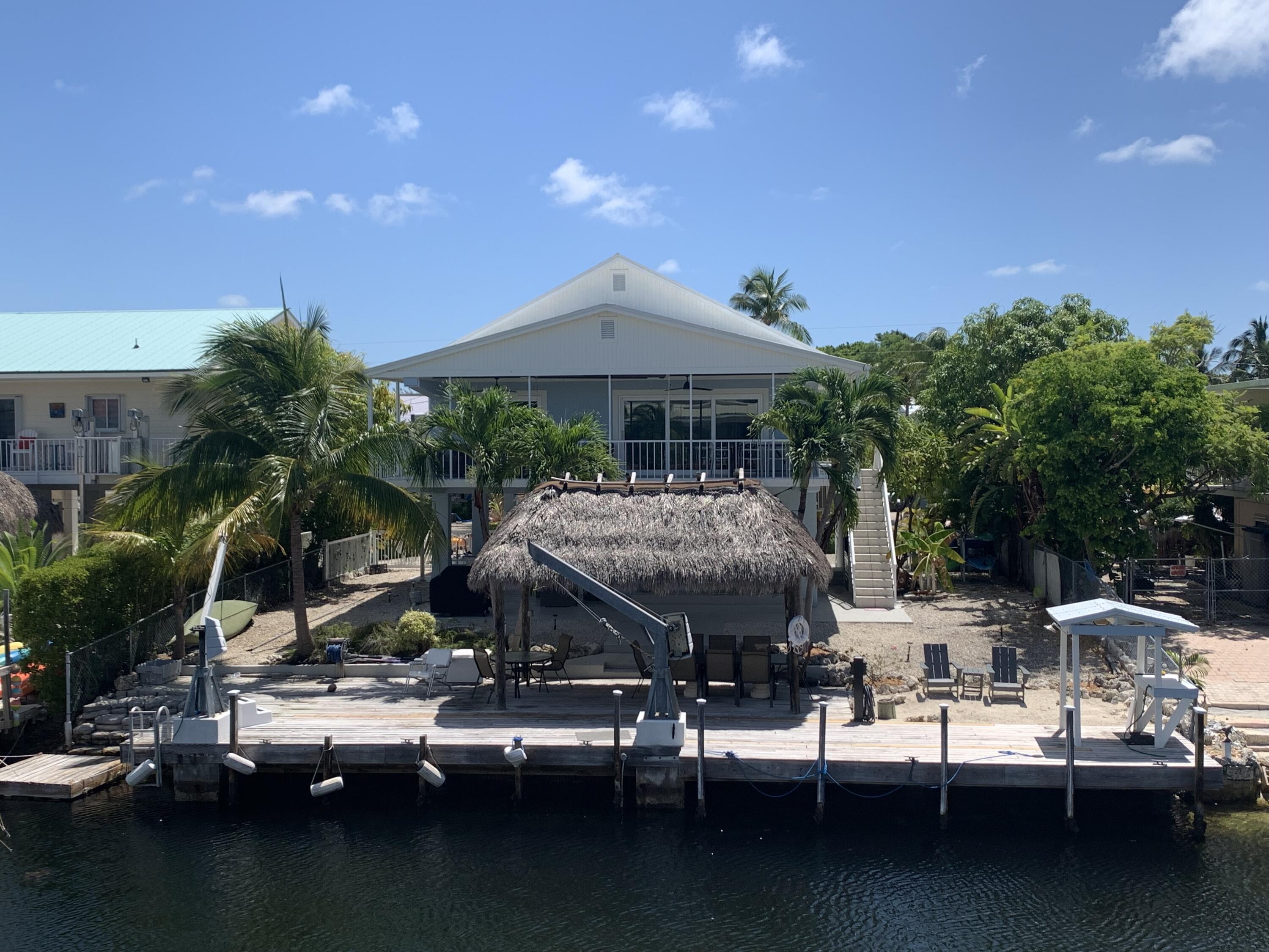 112 Captains Court Tavernier, FL 33070 - Photo 26 of 41 a view of pool with lawn chairs under an umbrella