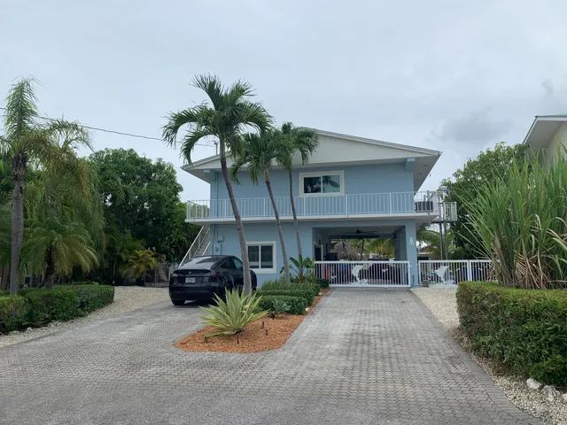 a view of house with lake view and a garden
