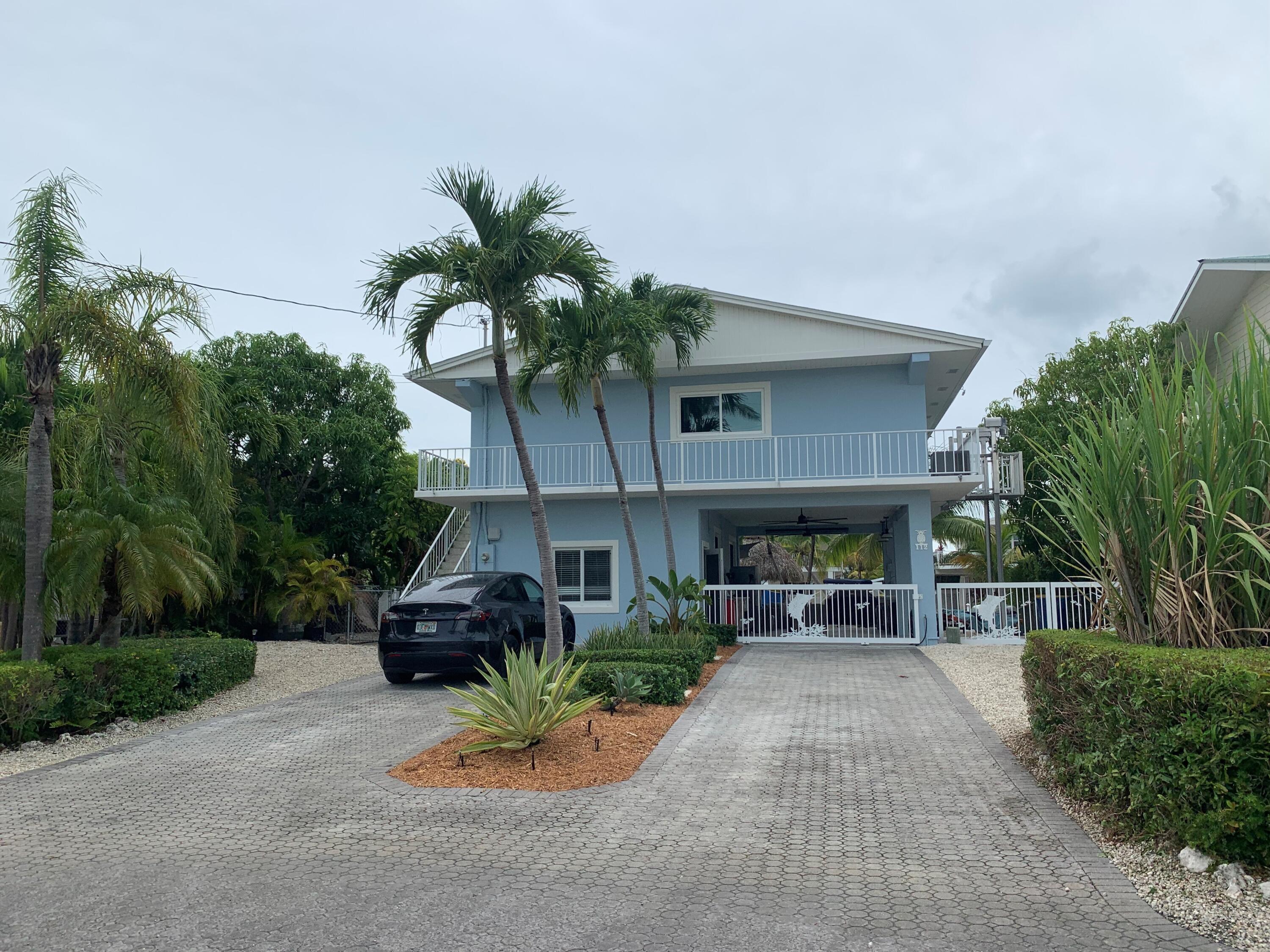 112 Captains Court Tavernier, FL 33070 - Photo 40 of 41 a front view of a house with a yard and a garage
