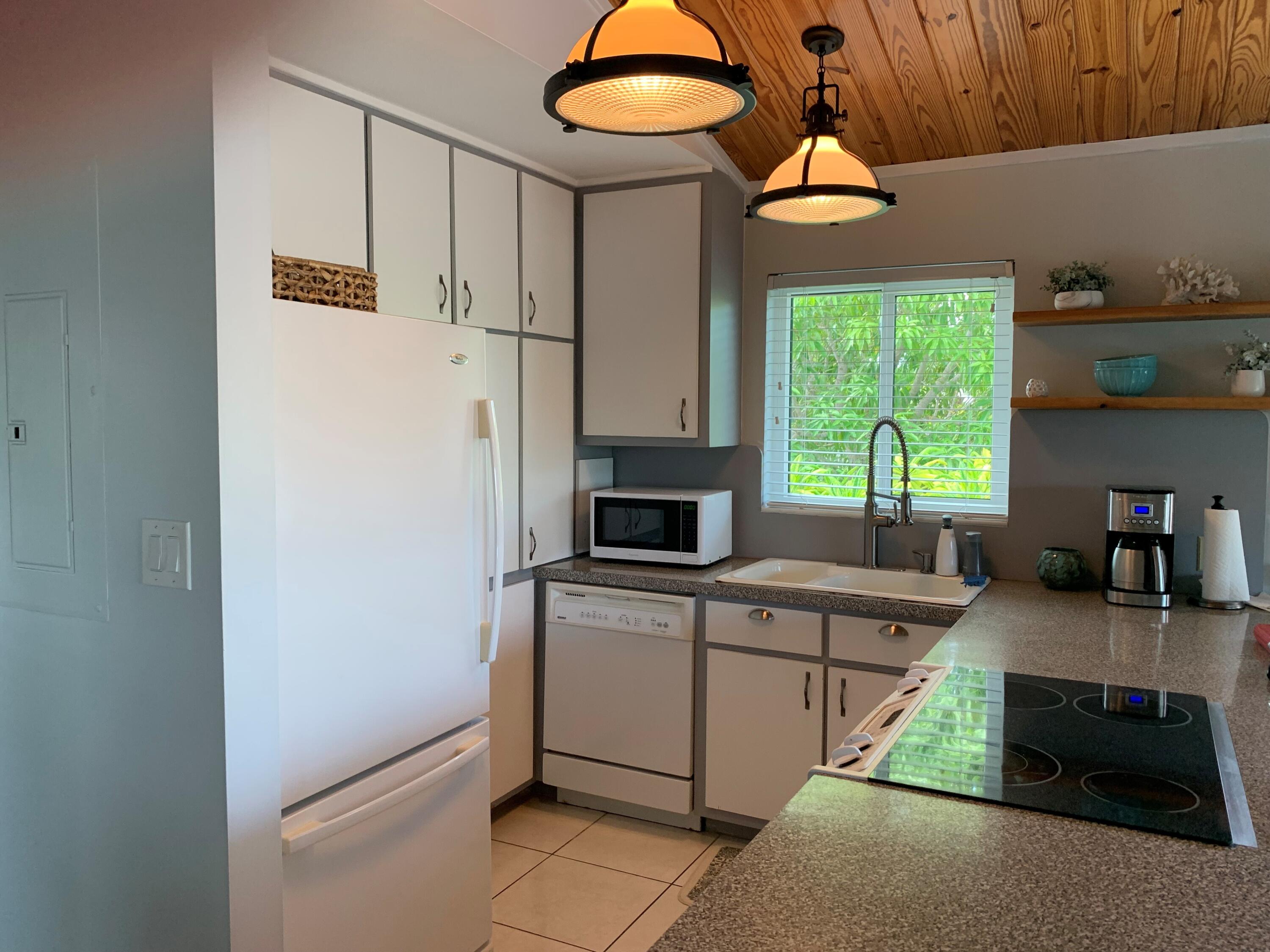 112 Captains Court Tavernier, FL 33070 - Photo 9 of 41 a kitchen with granite countertop a stove a sink and a microwave