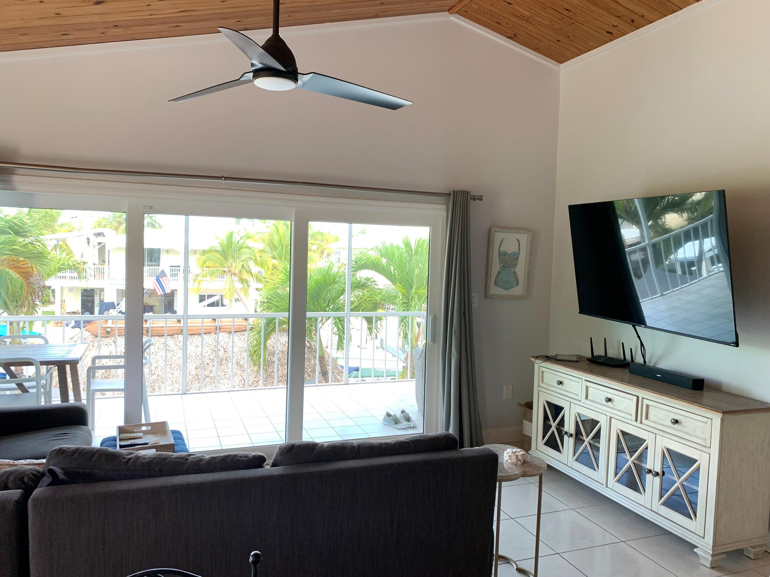 112 Captains Court Tavernier, FL 33070 - Photo 10 of 41 a living room with large window and a flat screen tv