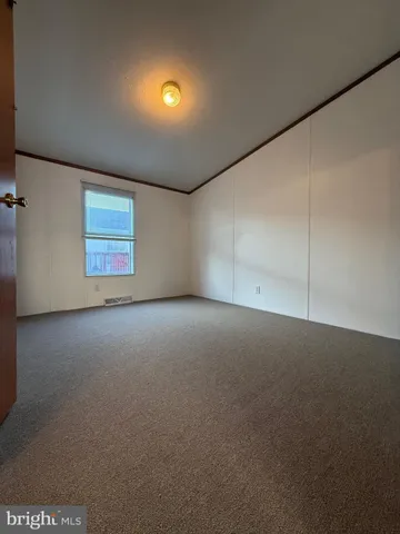 a view of a room with wooden floor white walls and a toilet
