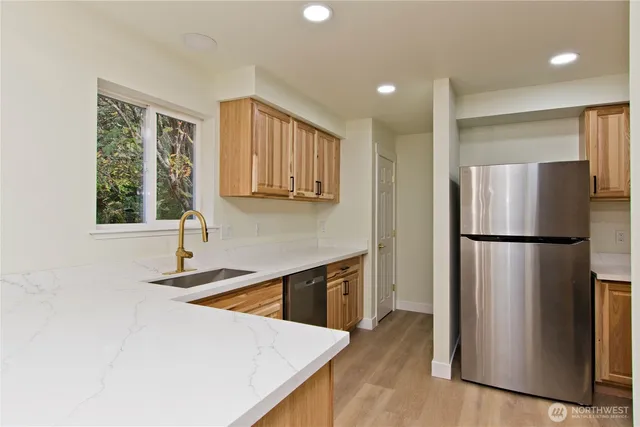 a kitchen with a refrigerator a sink and a window