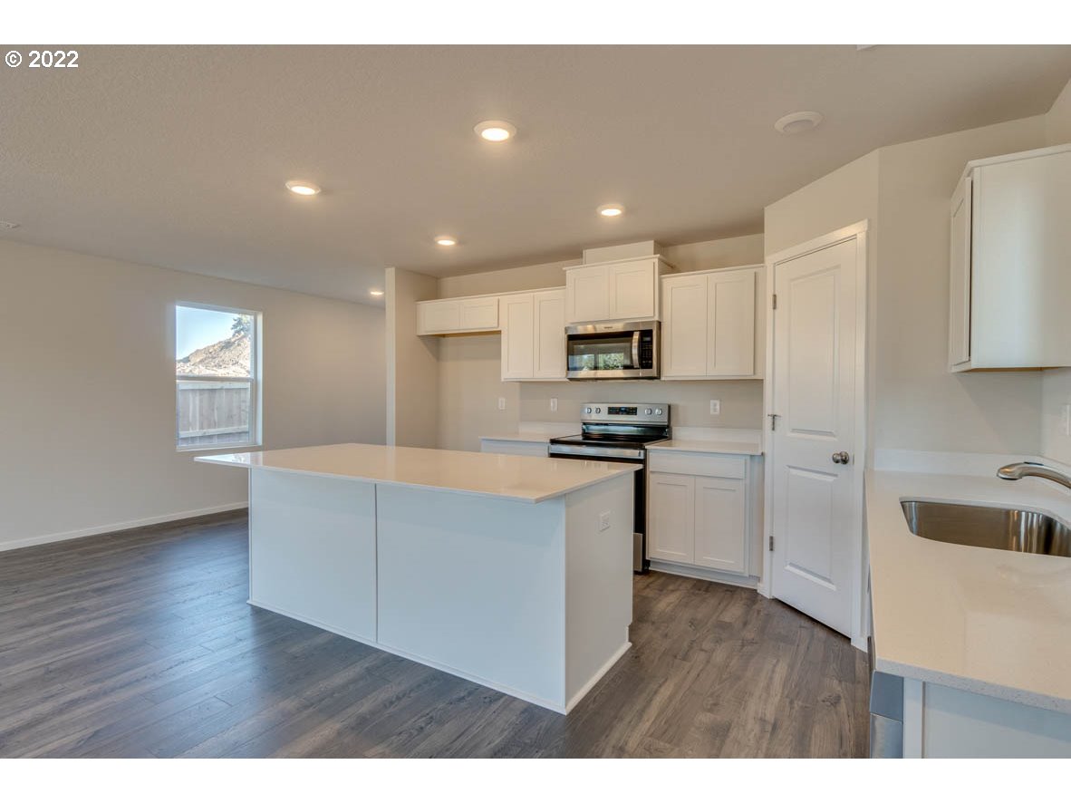 2945 North 3rd Way Ridgefield, WA 98642 - Photo 3 of 30 a kitchen with cabinets and wooden floor