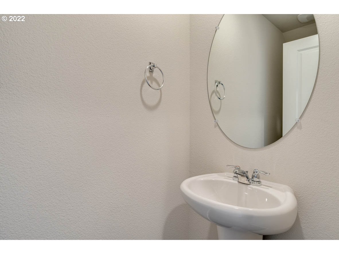 2945 North 3rd Way Ridgefield, WA 98642 - Photo 6 of 30 a bathroom with a sink a mirror and a fan