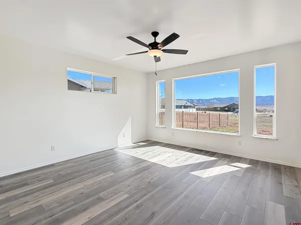 a view of a livingroom with wooden floor and a ceiling fan