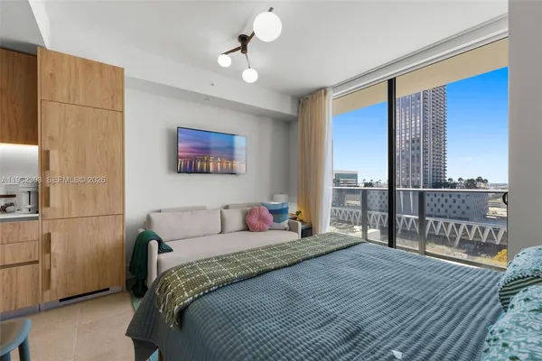 a bedroom with a large bed and a chandelier