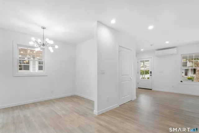 a view of kitchen with kitchen island a sink wooden floor and a refrigerator
