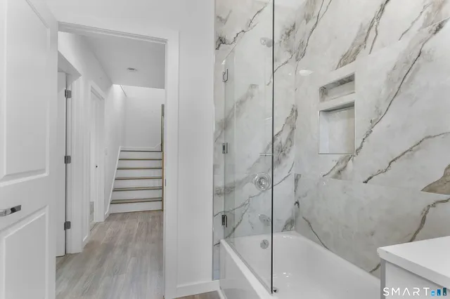 a bathroom with a tub sink and mirror