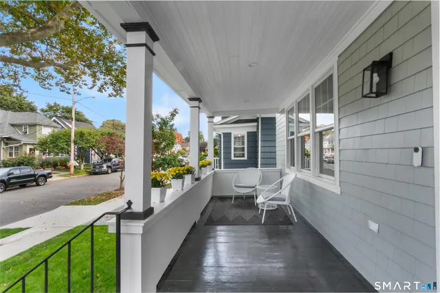 a balcony with wooden floor and outdoor seating