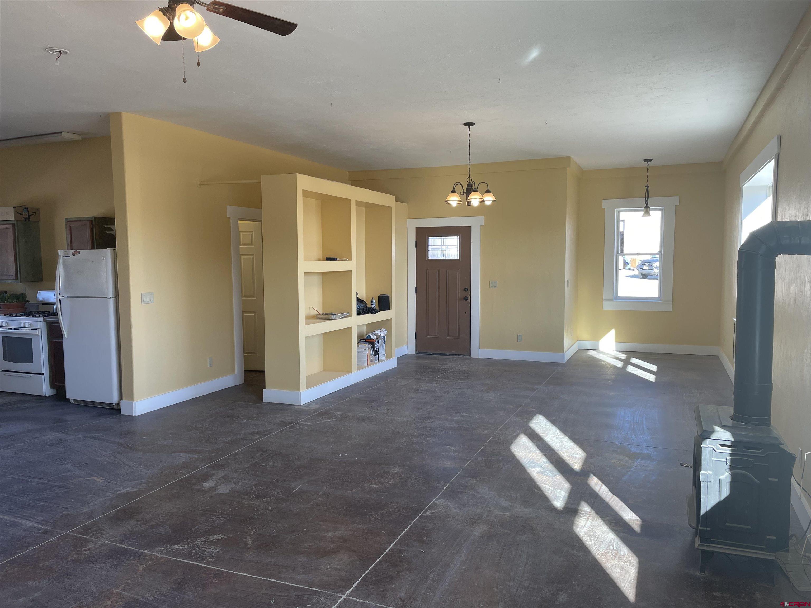 64233 Peach Valley Road Montrose, CO 81401 - Photo 8 of 26 an empty room with chandelier fan and windows