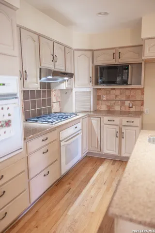 a kitchen with stainless steel appliances granite countertop a sink a stove and microwave