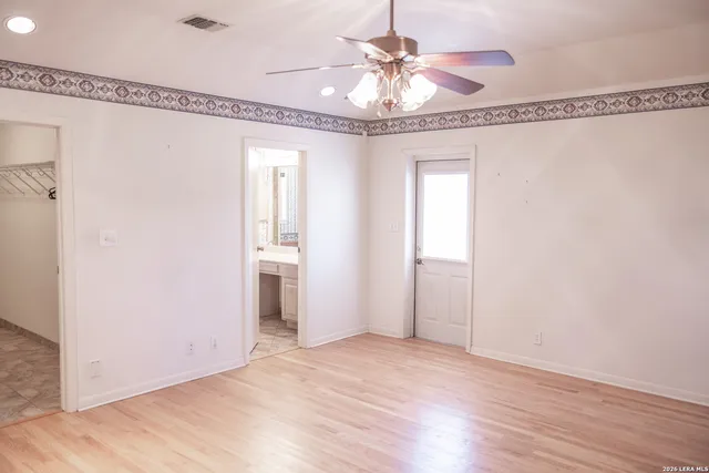 a view of a hallway with a chandelier fan and wooden floor