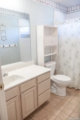 a bathroom with a toilet a sink and shower