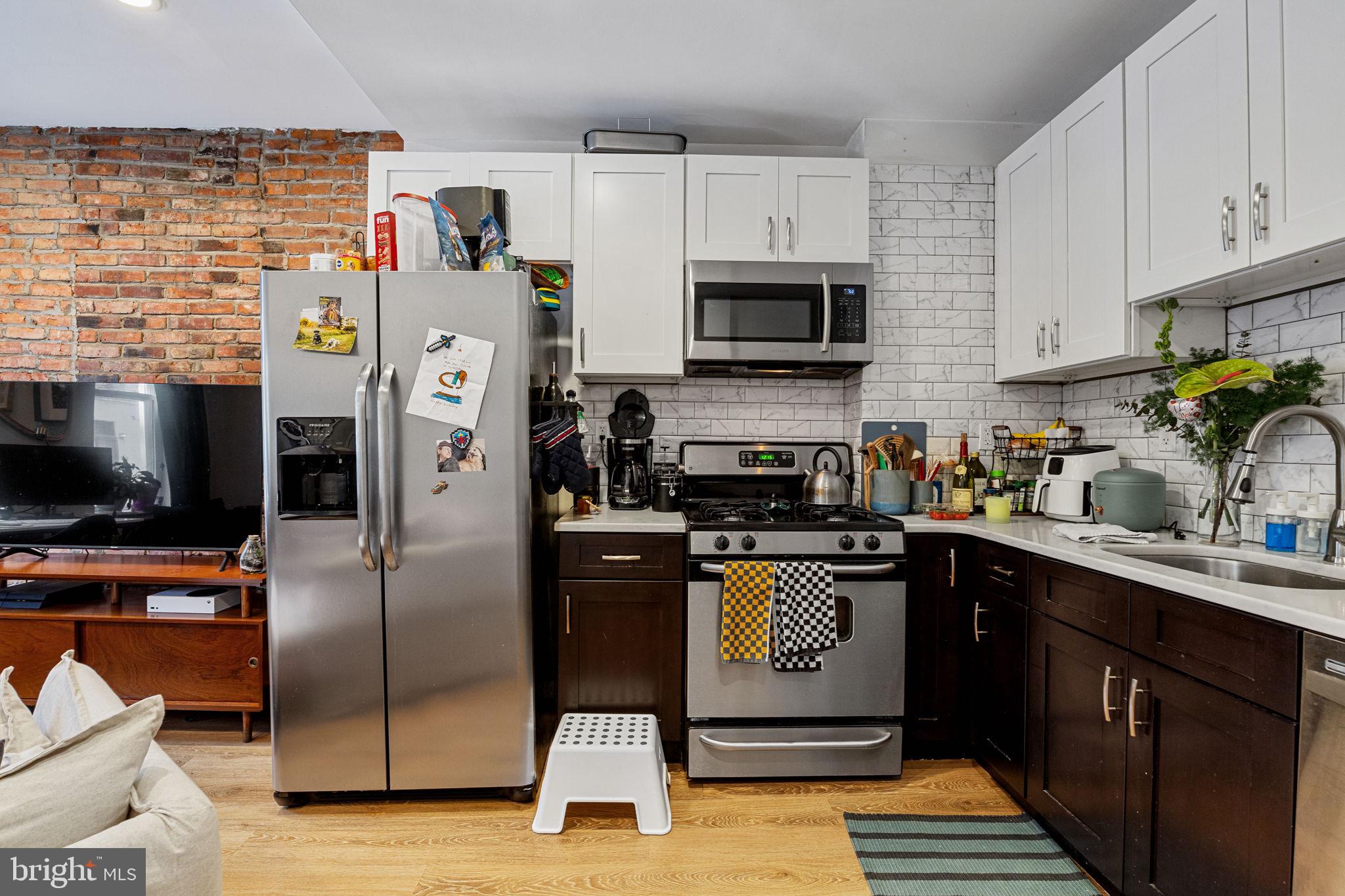 744 South 19th Street Philadelphia, PA 19146 - Photo 21 of 29 a kitchen with stainless steel appliances a refrigerator a sink a stove top oven a counter space and cabinets