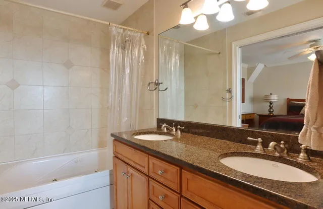 a bathroom with a granite countertop sink a mirror a shower and a bathtub