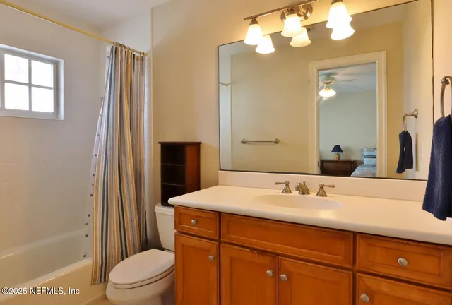 a bathroom with a sink a toilet and shower a mirror