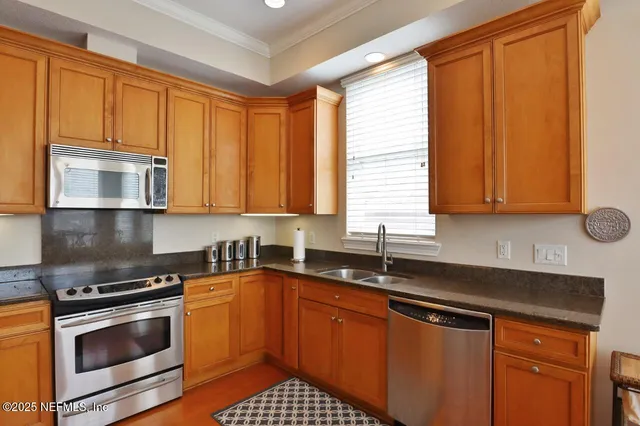 a kitchen with stainless steel appliances granite countertop a sink stove and microwave