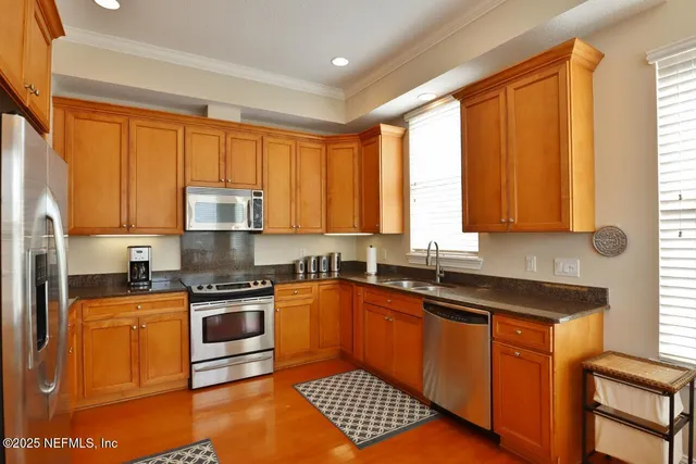 a kitchen with stainless steel appliances granite countertop a stove sink and cabinets