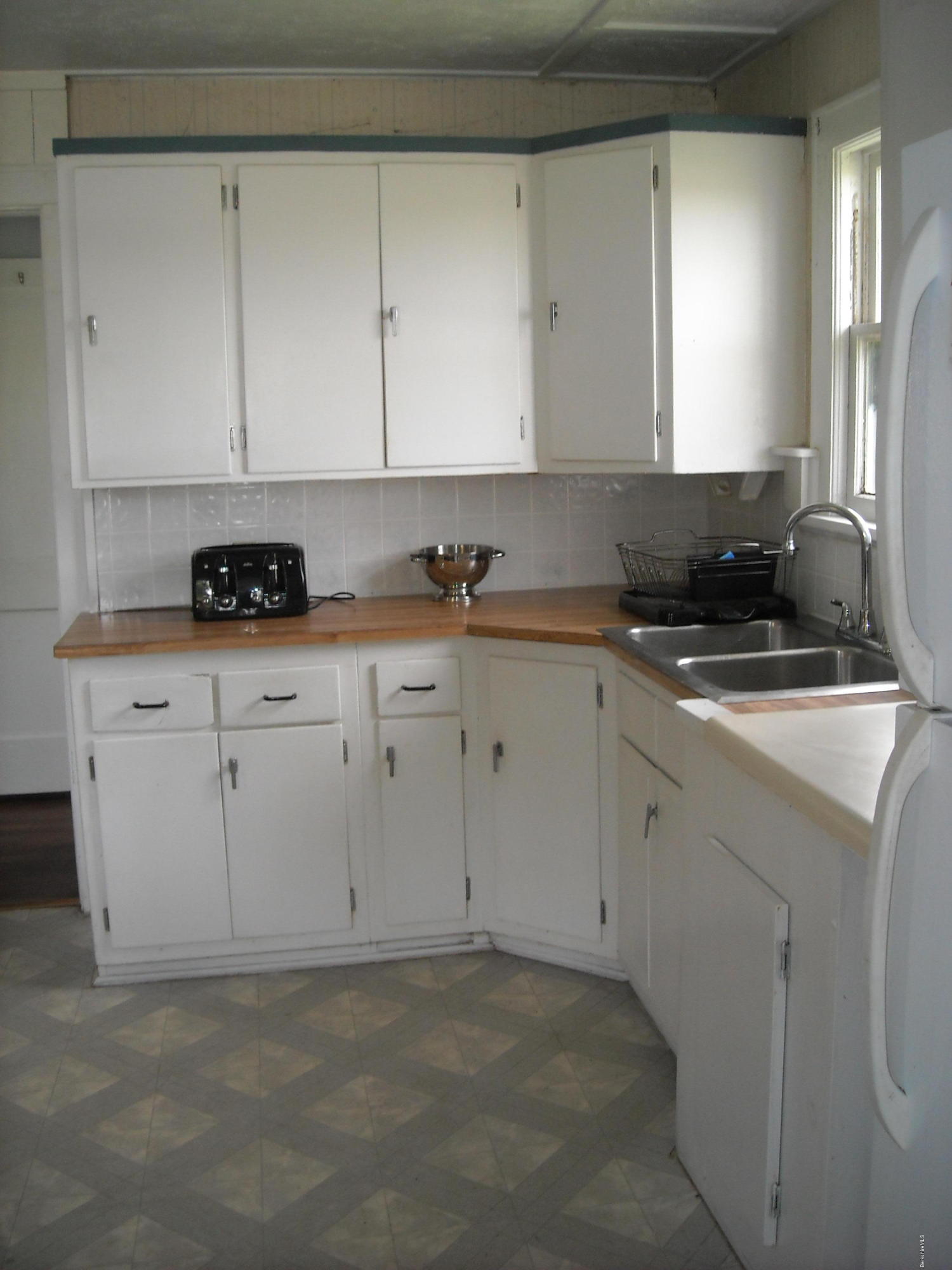 800 Tyringham Road Lee, MA 01238 - Photo 14 of 19 a kitchen with granite countertop white cabinets and white appliances