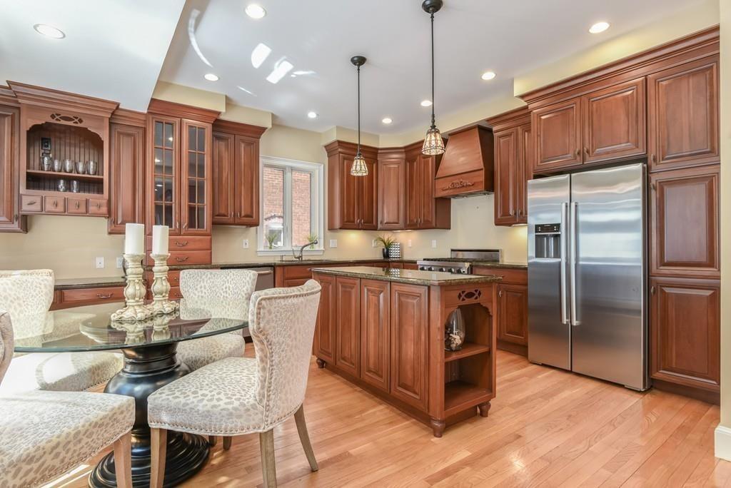 41 University Road Brookline, MA 02445 - Photo 11 of 37 a kitchen with stainless steel appliances granite countertop a refrigerator a stove a sink a dining table and chairs