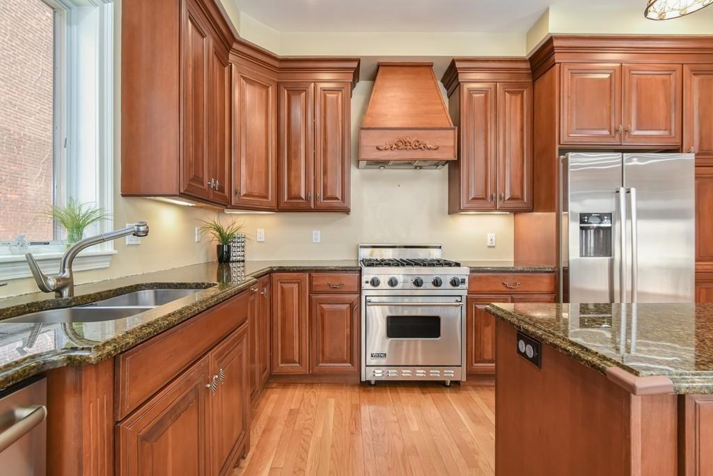 41 University Road Brookline, MA 02445 - Photo 15 of 37 a kitchen with stainless steel appliances granite countertop a sink a stove and a refrigerator