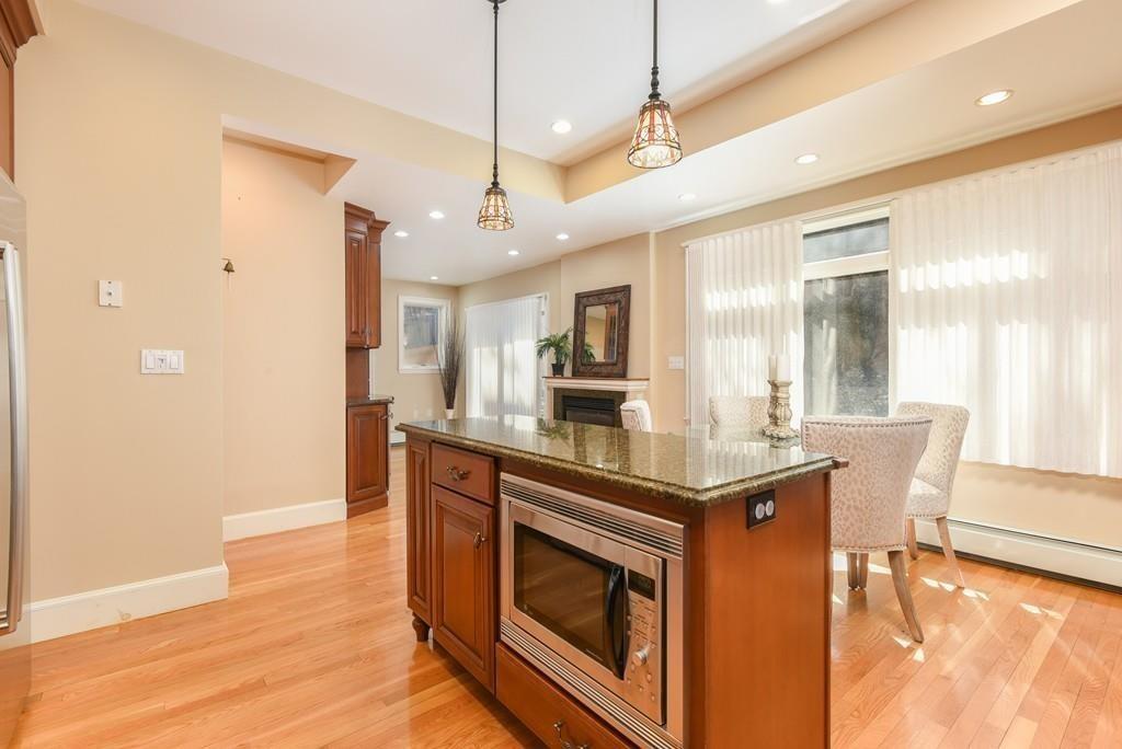 41 University Road Brookline, MA 02445 - Photo 16 of 37 a kitchen with stainless steel appliances granite countertop a stove and a wooden floors