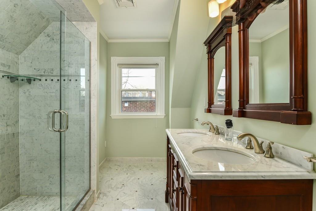 41 University Road Brookline, MA 02445 - Photo 33 of 37 a bathroom with a granite countertop sink a mirror and shower