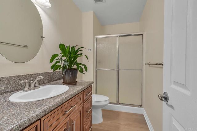 a bathroom with a granite countertop sink a toilet and a mirror